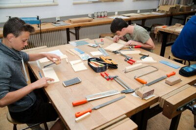 Schüler arbeiten an einem Werktisch